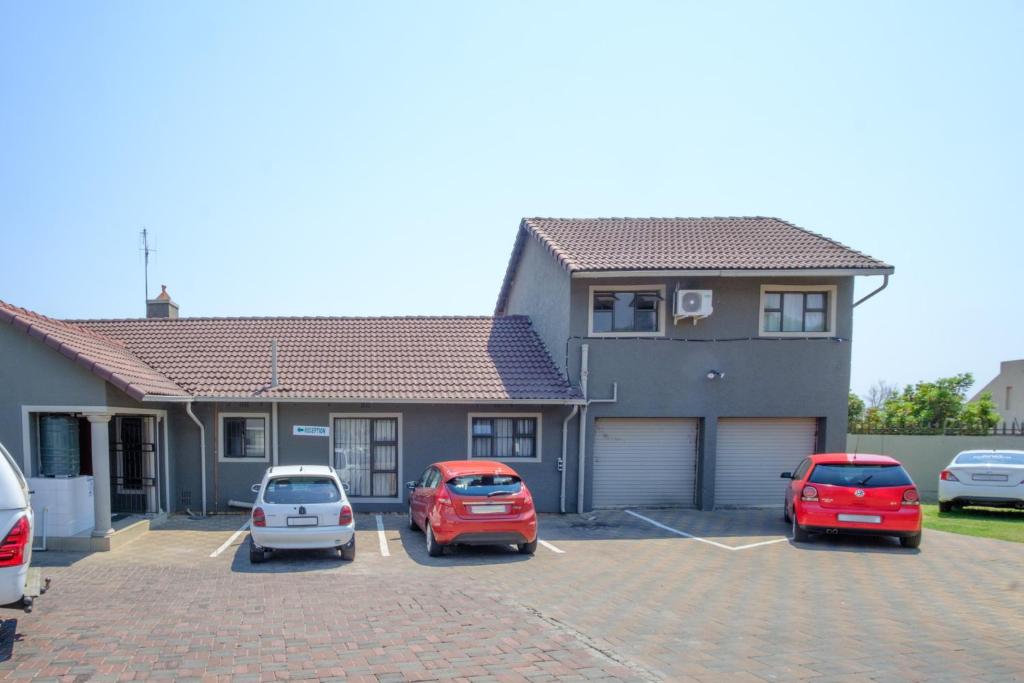 a group of cars parked in a parking lot in front of a house at Alimop Bed and Breakfast in Midrand