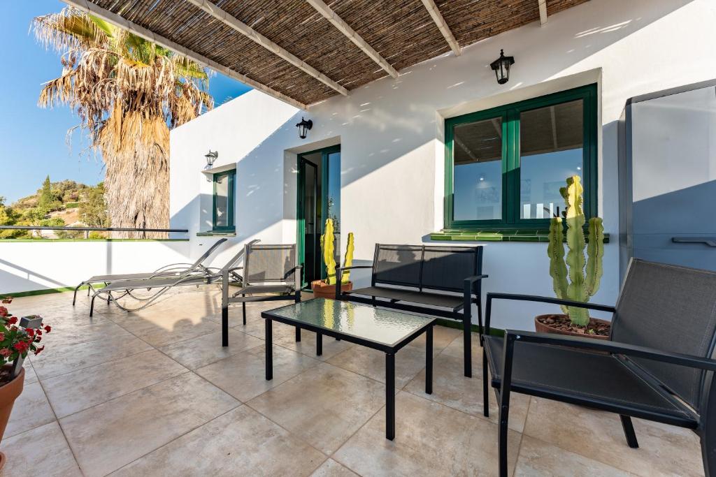 een patio met tafels en stoelen en een palmboom bij Apartamento Las Vistas in Mijas