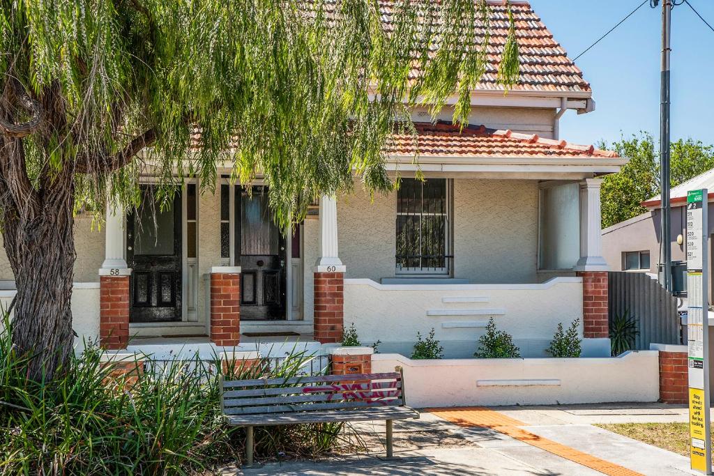 ein Haus mit einer Bank davor in der Unterkunft Captain's Heritage Cottage - central Fremantle 2 bedroom historic cottage in Fremantle