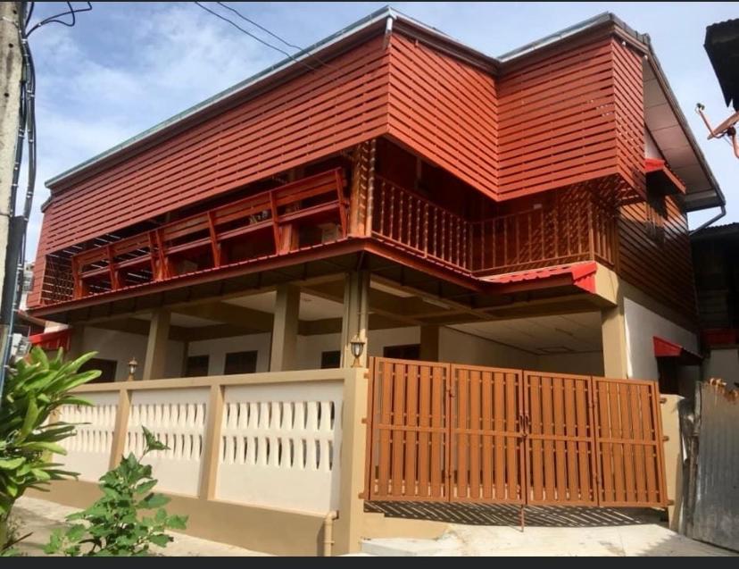 una casa con techo rojo y valla blanca en Baan Fun Dee Chiang Khan en Chiang Khan