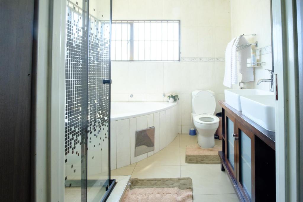 ein Badezimmer mit einer Badewanne, einem WC und einem Waschbecken in der Unterkunft Alimop Bed and Breakfast in Midrand