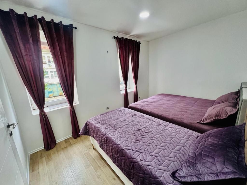 ein Schlafzimmer mit einem lila Bett und einem Fenster in der Unterkunft Apartmani Edo in Stolac