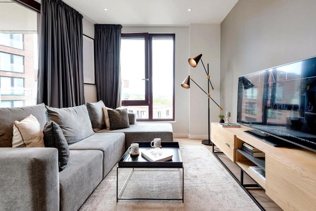 - un salon avec un canapé et une télévision dans l'établissement Gravity Camden Lock Apartments, à Londres