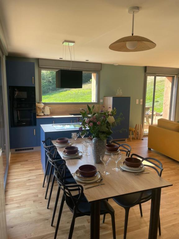 een keuken met een tafel met stoelen en een eetkamer bij Refuge au coeur des Vosges in Aumontzey