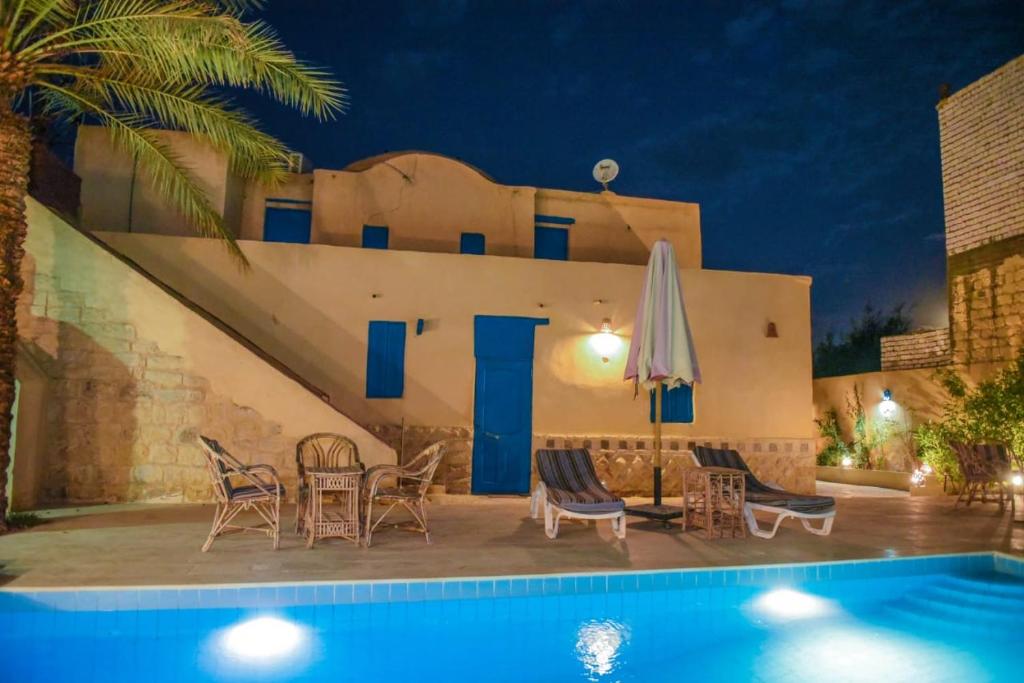 a villa with a swimming pool at night at Tunis village in Tunis