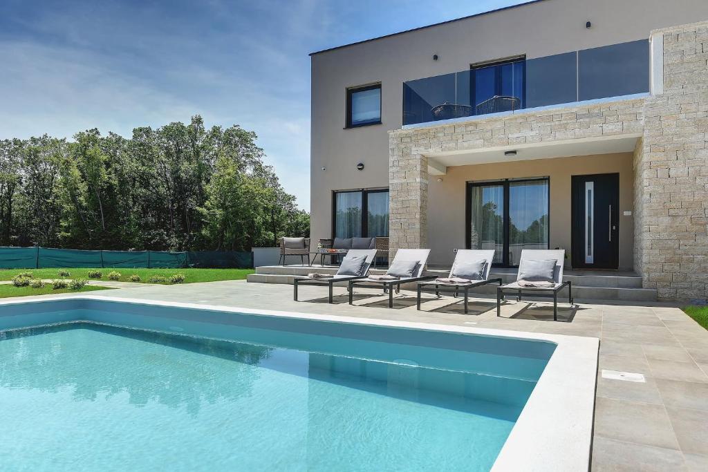 una piscina frente a una casa en Modern villa Omnia with pool and grill in Pula en Loborika