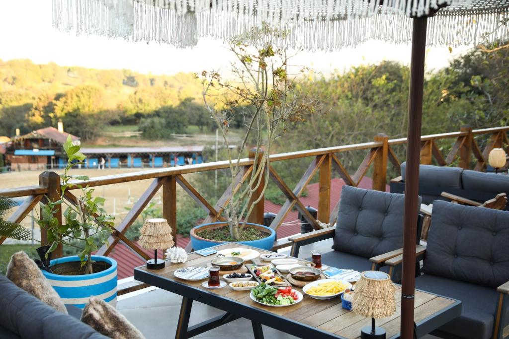 a table with food on top of a balcony at MAVİ AT HOTEL Blue Horse in Gümüşdere