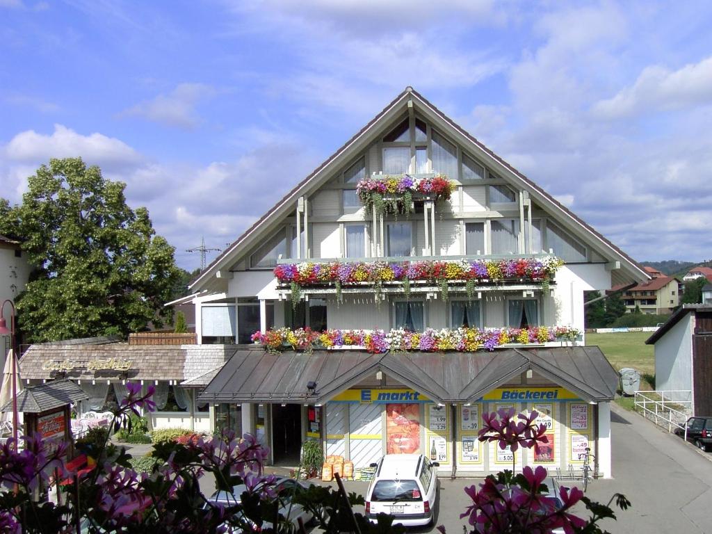 un gran edificio blanco con cajas de flores. en Schwarzwald-Pension Fechtig, en Ühlingen-Birkendorf