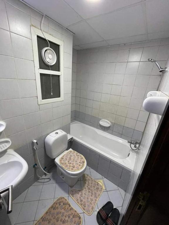 a bathroom with a toilet and a sink and a tub at شقق فندقيه in Dubai