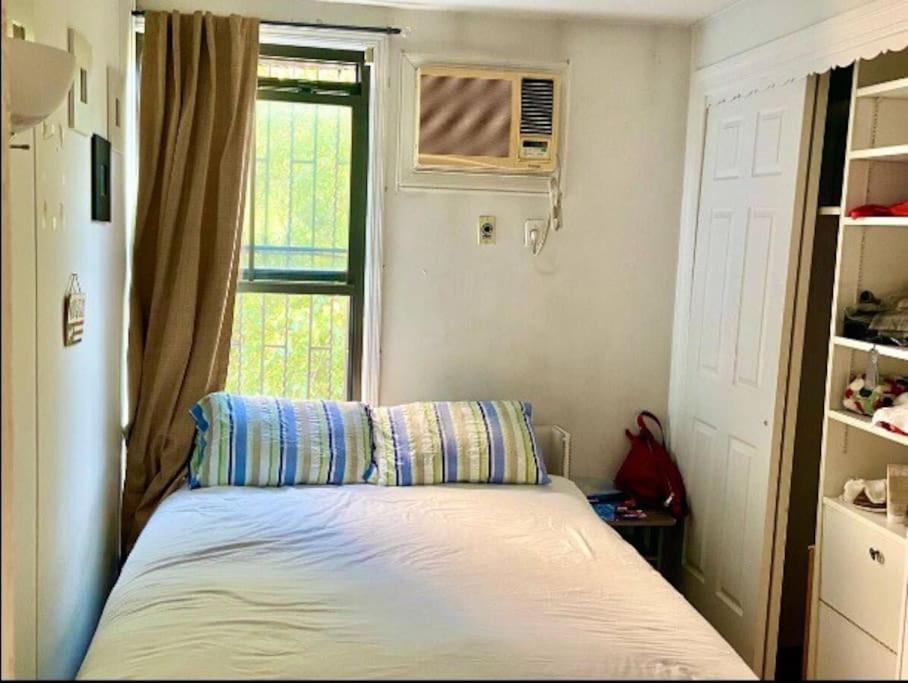 ein kleines Schlafzimmer mit einem Bett und einem Fenster in der Unterkunft Cozy room at great Townhouse in Williamsburg in Brooklyn