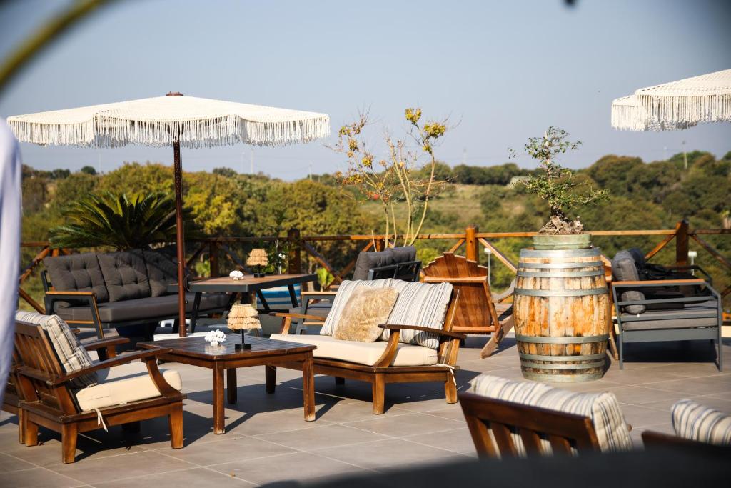 a patio with chairs and tables and an umbrella at MAVİ AT HOTEL Blue Horse in Gümüşdere