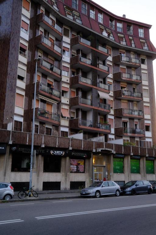 ein hohes Gebäude mit davor geparkt in der Unterkunft Comodo appartamento in Baranzate