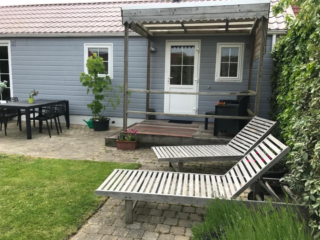 a blue tiny house with a table and a bench at Bungalow De Perenboom in Westkapelle