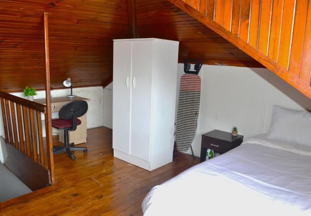 a bedroom with a bed and a desk in a room at 149 ROCHESTER ROAD. OBSERVATORY in Cape Town