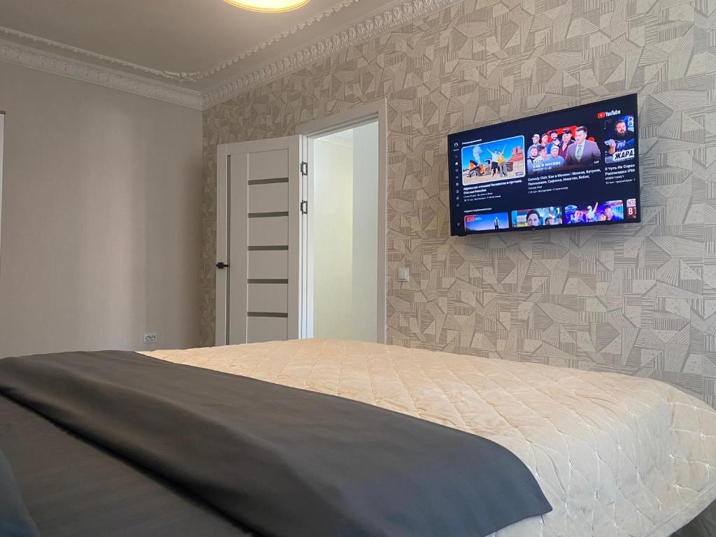 キシナウにあるCentral City 1 Bedroomのベッドルーム1室(ベッド1台、壁掛け式薄型テレビ付)
