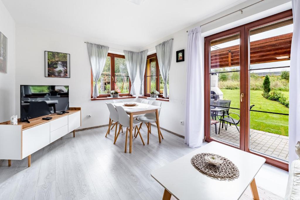 sala de estar con mesa, sillas y TV en Apartmán Jasmin, en Frymburk