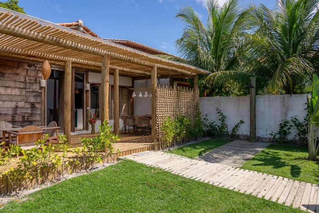 ein Haus mit einer Terrasse und einem Hof in der Unterkunft Casa Nuhatê Trancoso - Praia do Espelho in Praia do Espelho