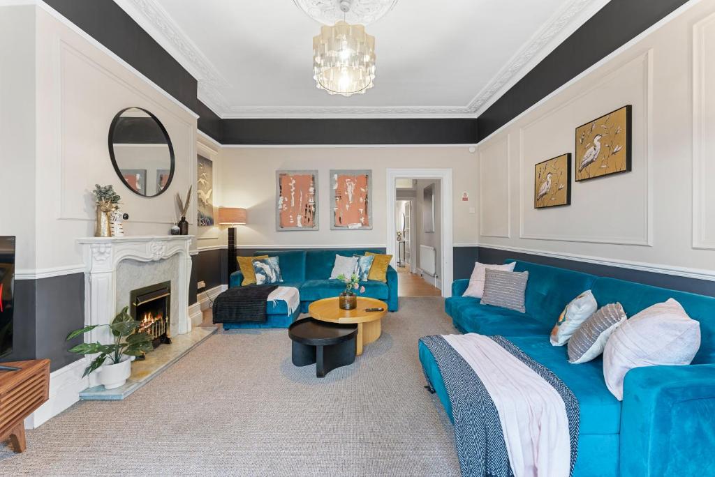 sala de estar con sofá azul y chimenea en Lovely 2 bedroom apartment - Sleeps 9, en Bristol