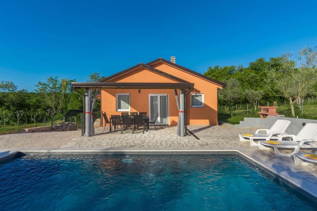 une maison avec une piscine en face d'une maison dans l'établissement Villa Pendolina with pool and grill in Umag, à Buroli