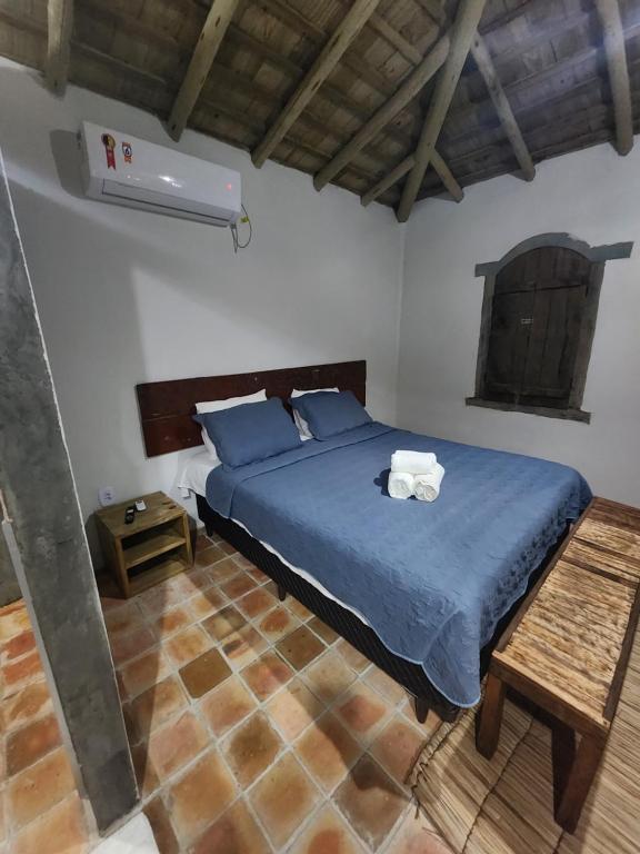 um quarto com uma cama azul com duas toalhas em Nuhatê Casa Hotel em Caraíva