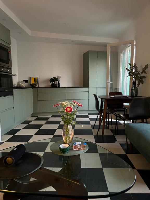 un salon avec une table avec un vase de fleurs dans l'établissement Charmant appartement 2 chambres à 10mn de la plage., à Marseille