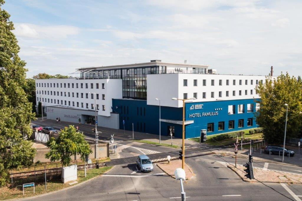 duży biały budynek z ulicą przed nim w obiekcie Hotel Famulus w Győr