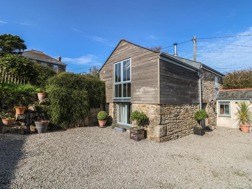 a small stone house with a gravel driveway at Hay Loft in Camborne