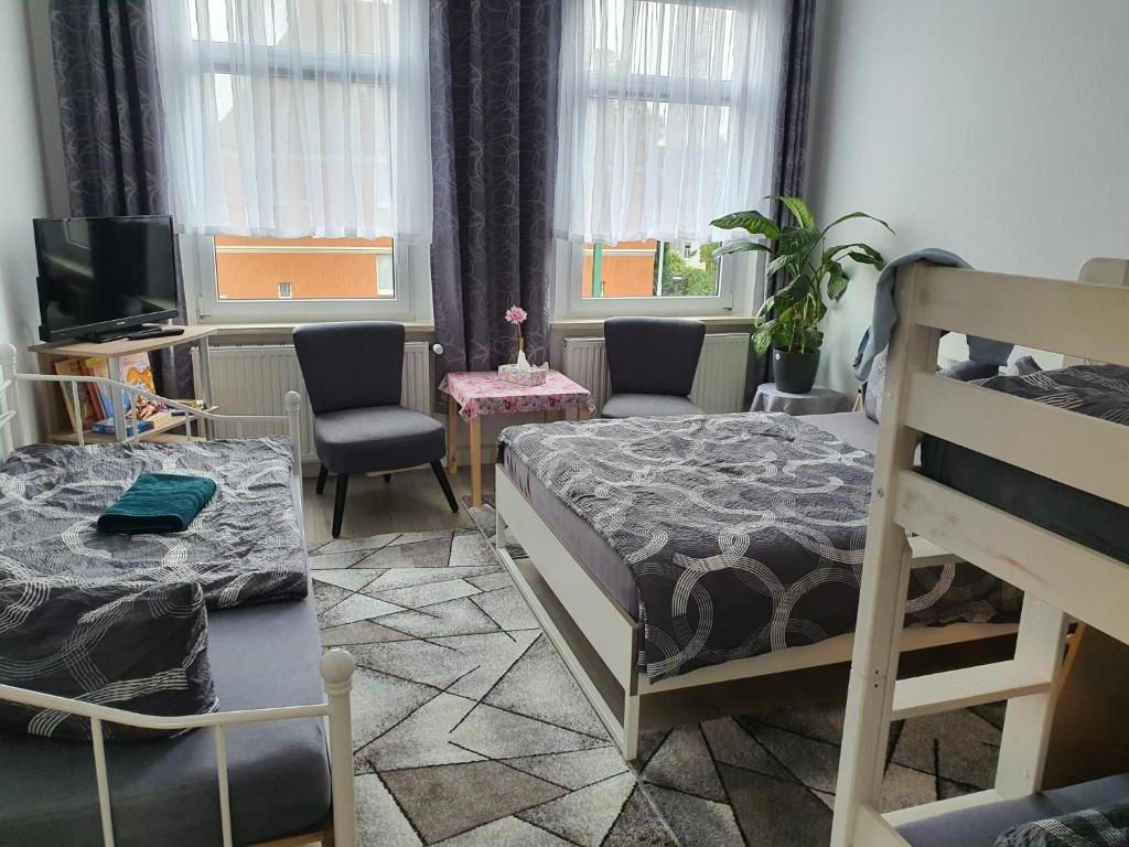 1 Schlafzimmer mit 2 Etagenbetten und einem TV in der Unterkunft Halle Saale 402 in Ammendorf