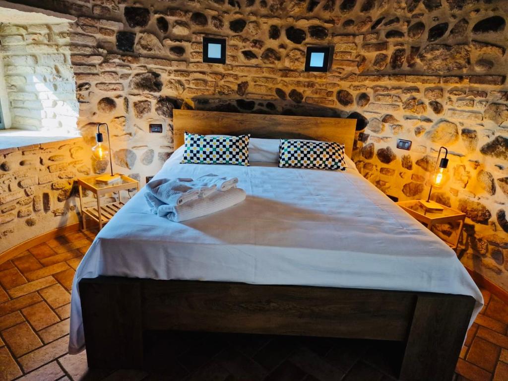 ein Schlafzimmer mit einem großen Bett in einer Steinmauer in der Unterkunft Vittoria alla Torre in Pozzolengo