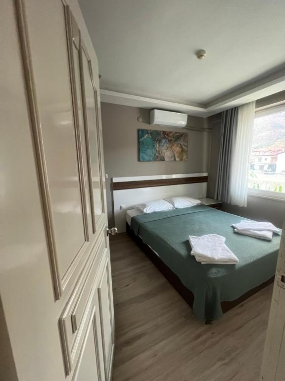 a bedroom with a green bed and a window at Imperial Apart in İçmeler
