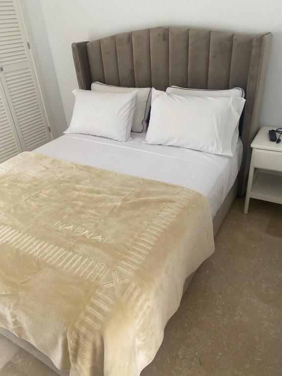 ein Bett mit weißen Kissen und einer Decke darauf in der Unterkunft Villa puerto banuus Marbella in Marbella