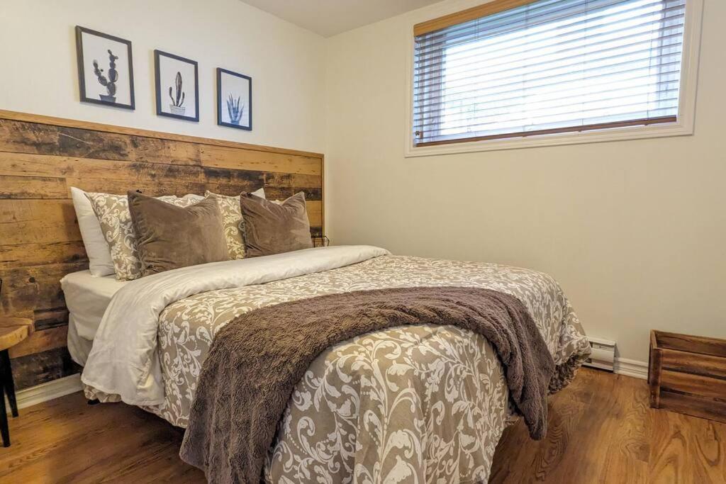 Un dormitorio con una cama grande y una ventana en 2 bedrooms apartment with private parking 5 minutes from Montreal, en Longueuil