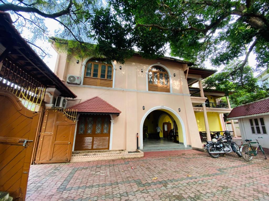 a large house with a driveway in front of it at Ballard Bungallow in Cochin
