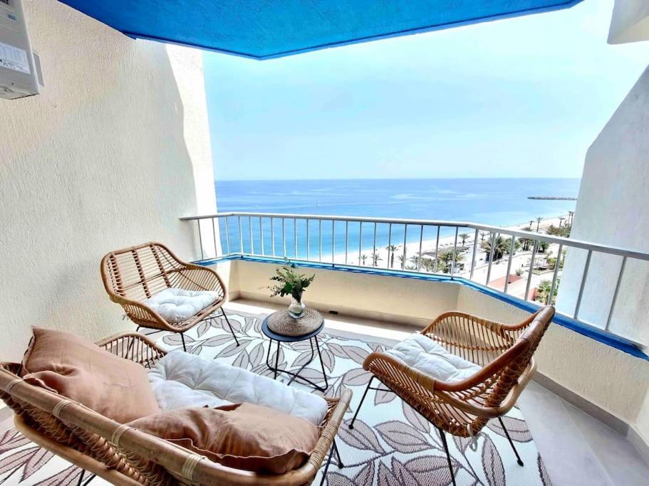Un balcón con sillas, una mesa y el océano en Almuñecar Seawiews Deluxe SinEsedesignhomes, en Almuñécar