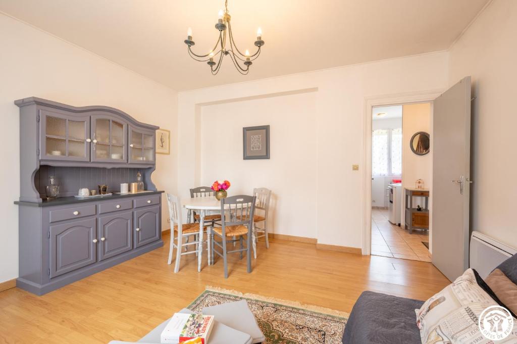uma cozinha e sala de estar com mesa e cadeiras em Les 26 Tanneurs appartement em Noyon
