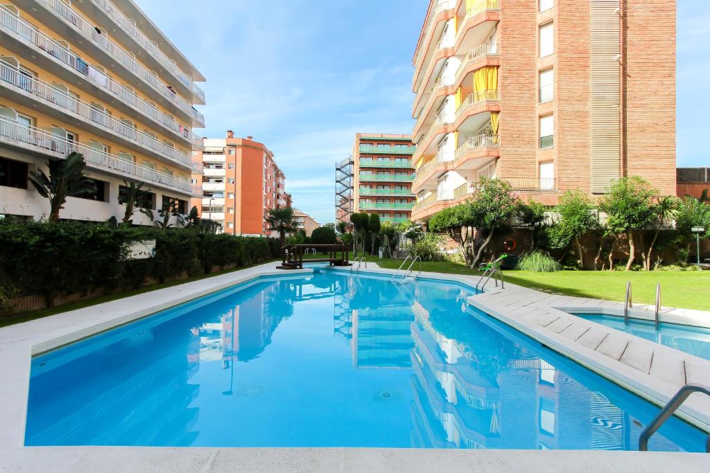 a swimming pool in a building with tall buildings at Apartamento Disa in Lloret de Mar