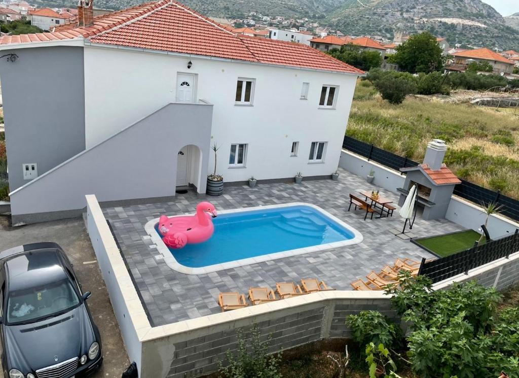a villa with a swimming pool in front of a house at Villa Felicita in Trogir