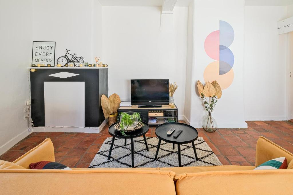 a living room with a couch and a tv at Numéro 6 - Place Nationale - Wifi et Fibre in Montauban