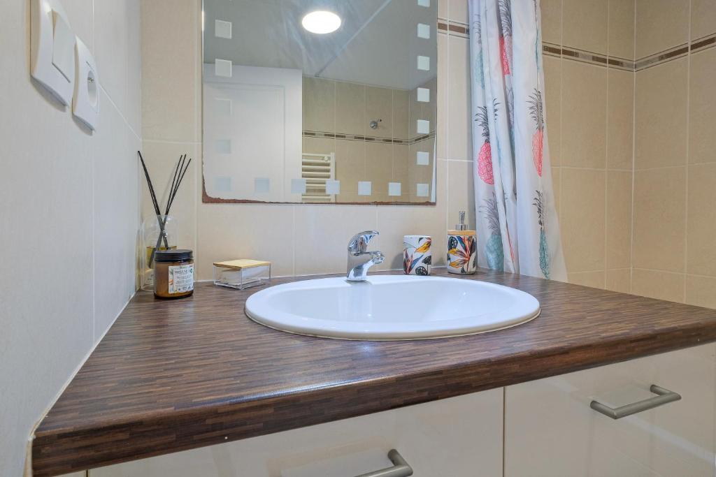 a bathroom with a white sink and a mirror at Numéro 6 - Place Nationale - Wifi et Fibre in Montauban