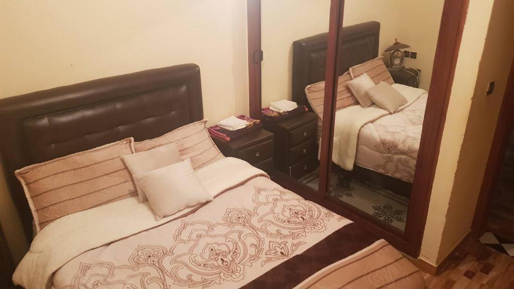 um quarto com uma cama e um espelho em Apartement Beni Mellal ain assrdoun em Beni Mellal