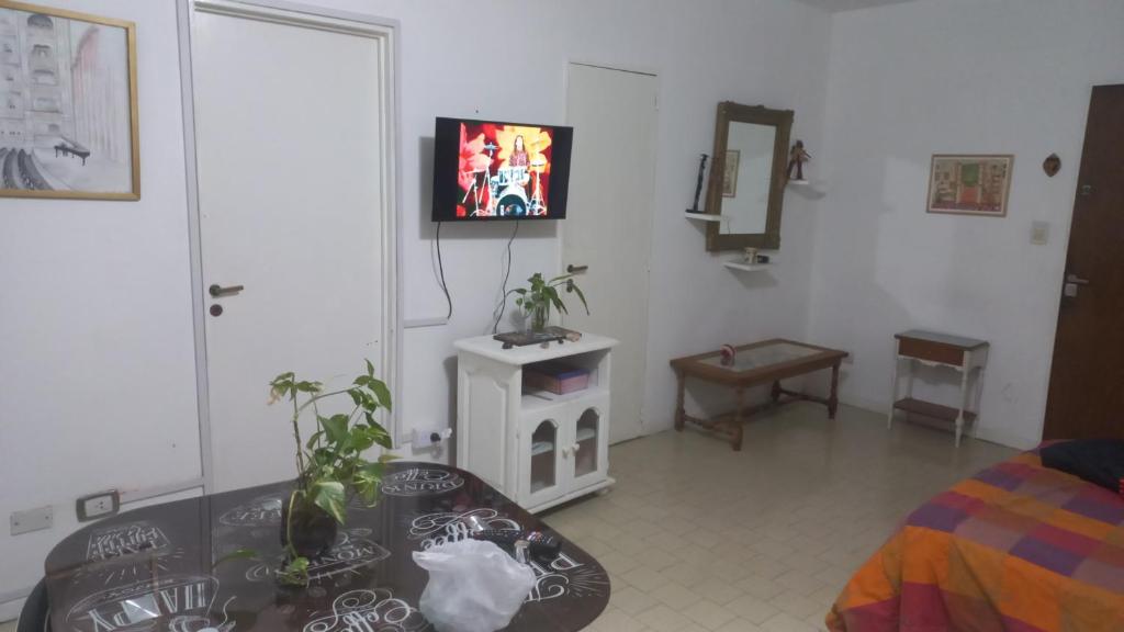 - un salon avec une table et une télévision murale dans l'établissement Vista verde encantadora, à Buenos Aires