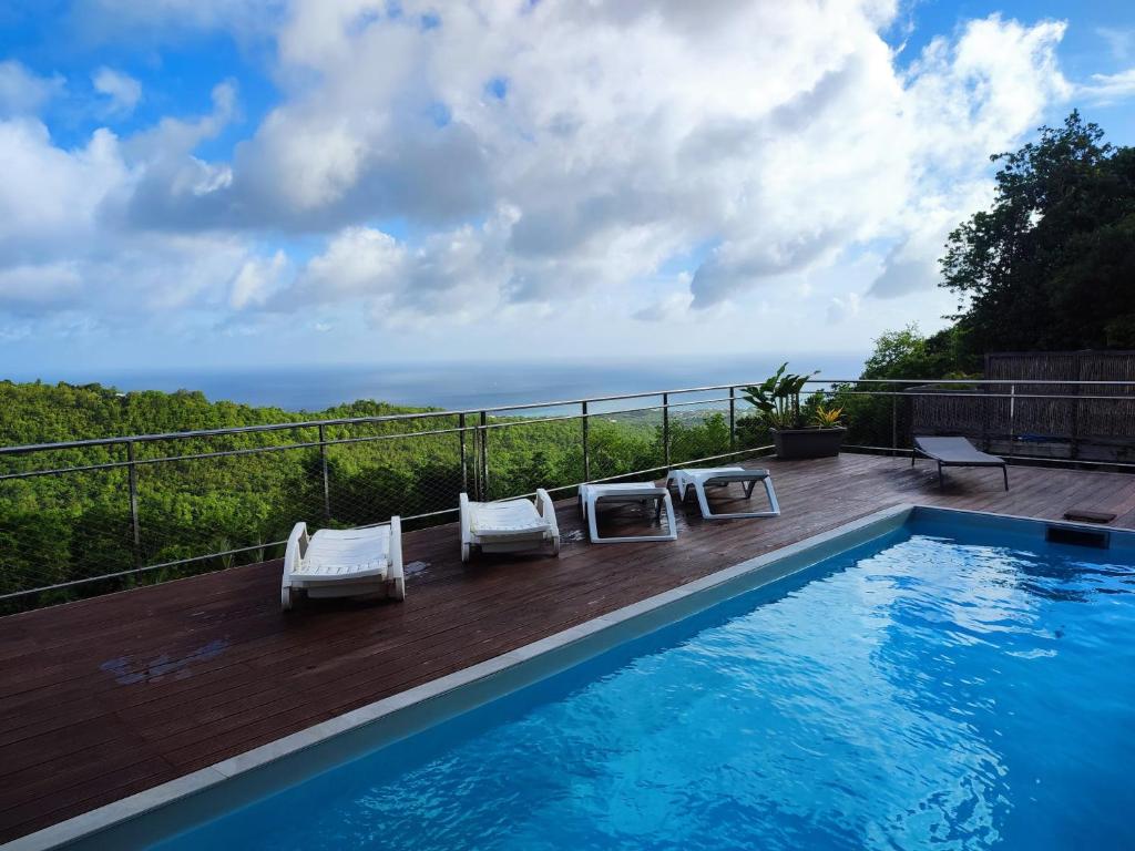 a swimming pool with two lounge chairs next to at Villa Madjic in Sainte-Luce