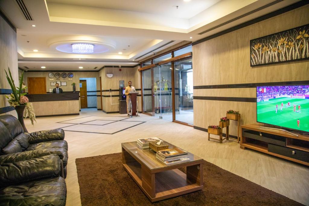 Juffair Trends Luxury Apartment في الجفير: غرفة معيشة مع تلفزيون وأريكة