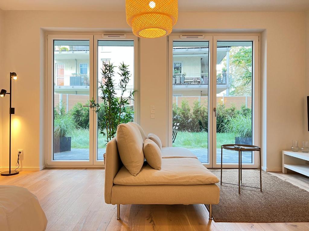 sala de estar con silla y ventanas en Newly Build Apartment In Hamburg City Center, en Hamburgo