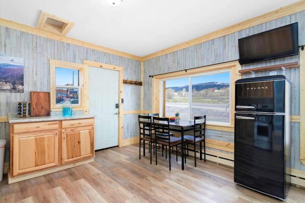 a kitchen with a black refrigerator and a table with chairs at 12Private Room with Kitchen Dog Friendly Leadville in Leadville