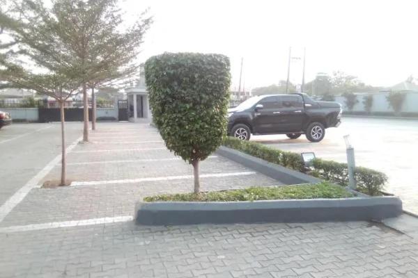a small bush in a parking lot with a truck at Leawood Hotel in Lekki