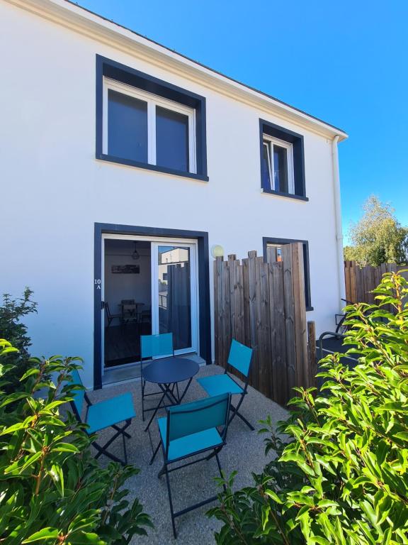 une maison avec des chaises bleues et une terrasse dans l'établissement Le Petit Hérisson joli logement au rez-de-jardin à Les Herbiers, aux Herbiers