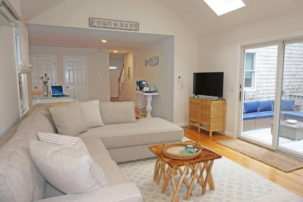 ein Wohnzimmer mit einem Sofa und einem Tisch in der Unterkunft Wedgewood Cottage in Barnstable