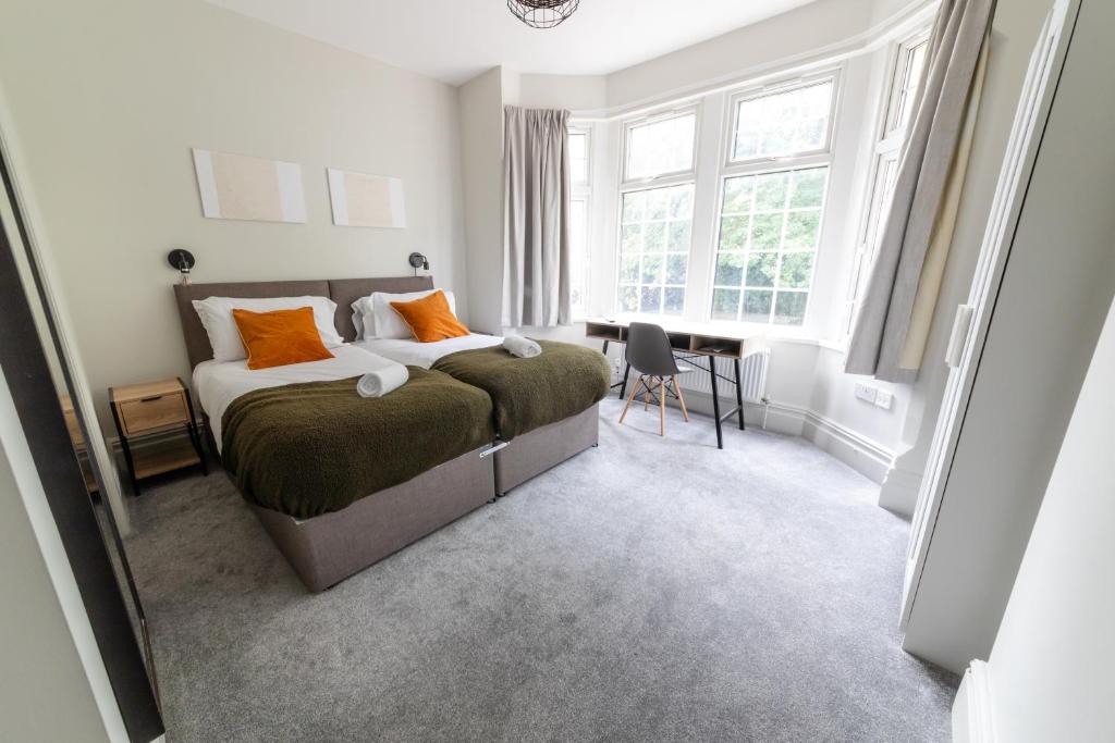 a bedroom with a bed with orange pillows and a desk at NEWLY REFURBISHED House - FREE Wi-Fi! in Wyken