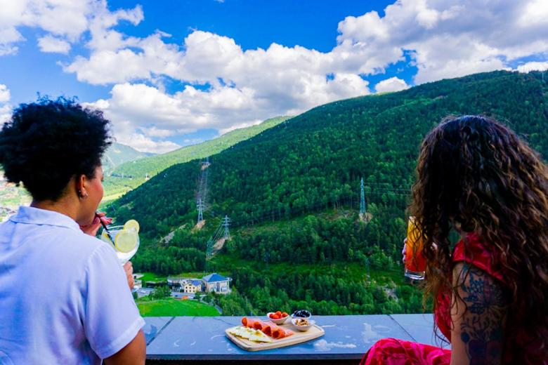 dos personas sentadas en una mesa mirando una montaña en Hotel Ransol, en El Tarter